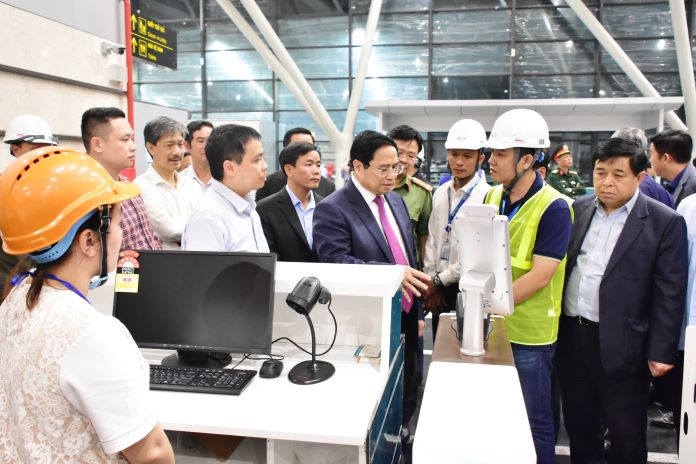 Thủ tướng nghe giới thiệu về hệ thống check-in tự động liên kết với hệ thống cơ sở dữ liệu dân cư quốc gia.