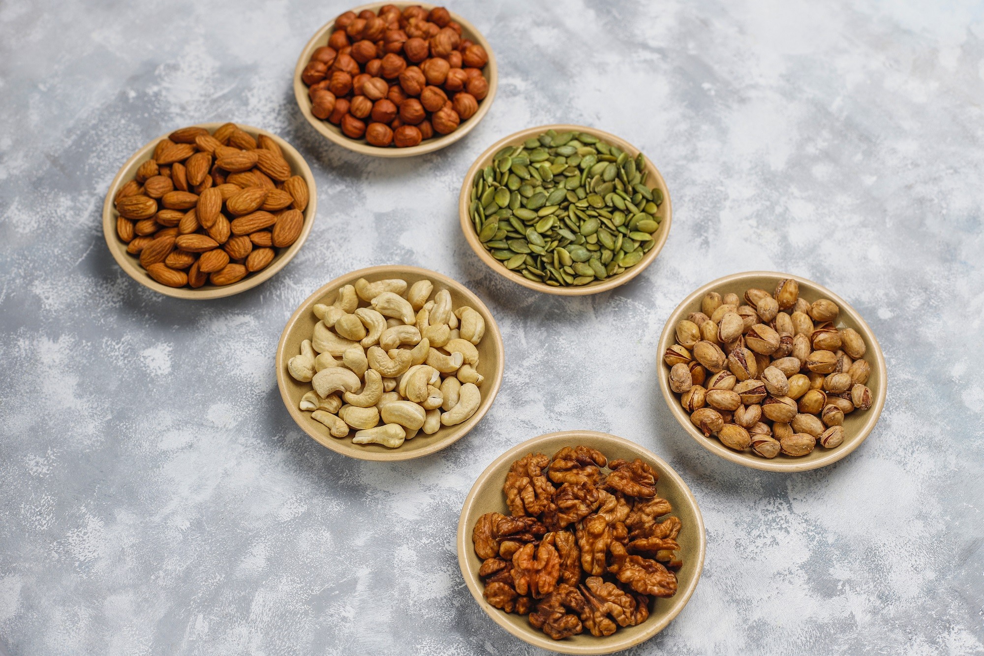 assortment-nuts-ceramic-plates-cashew-hazelnuts-walnuts-pistachio-pecans-pine-nuts-peanut-raisins-top-view-1727753012.jpg