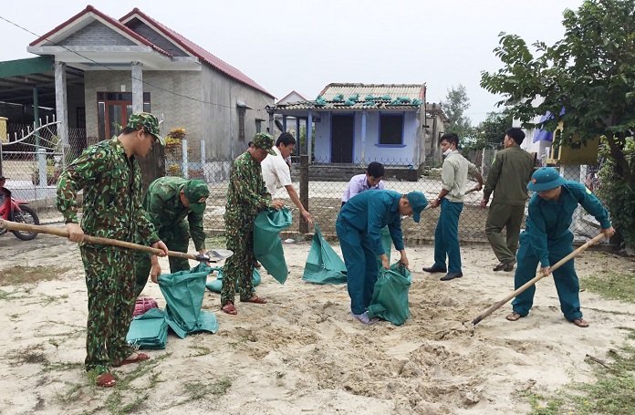 Cán bộ, chiến sĩ Ban CHQS huyện và lực lượng dân quân huyện Phong Điền chằng chống nhà cửa cho bà con nhân dân.